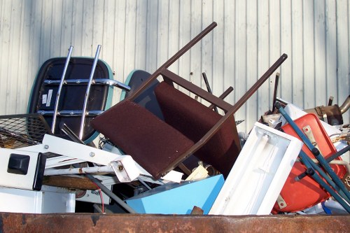 Business staff using a sustainable rubbish area with labelled recycling bins